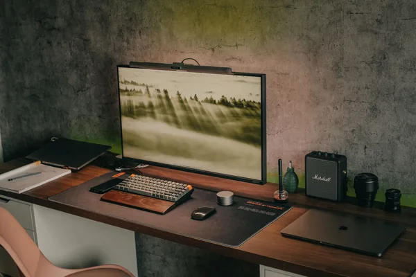 A cozy home office setup featuring a monitor, keyboard, and electronic accessories.