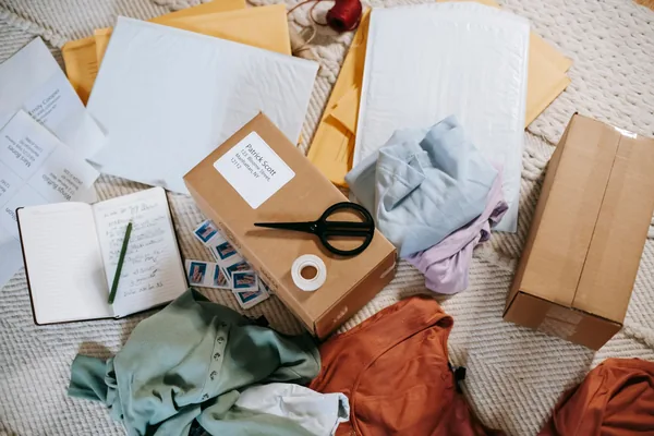 From above of various carton boxes and labels near clothes on surface in room