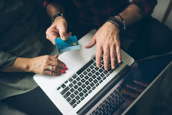 Two people at home reviewing finances and a card, overhead view