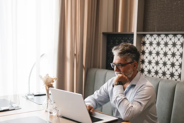 A man working on a laptop at a table at home