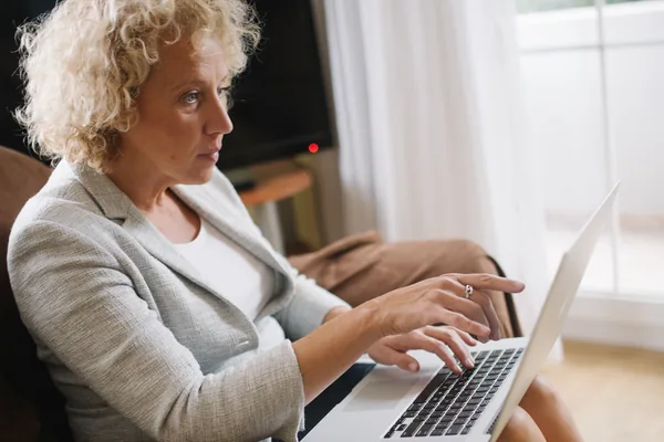 An older adult examining and pointing at a laptop screen